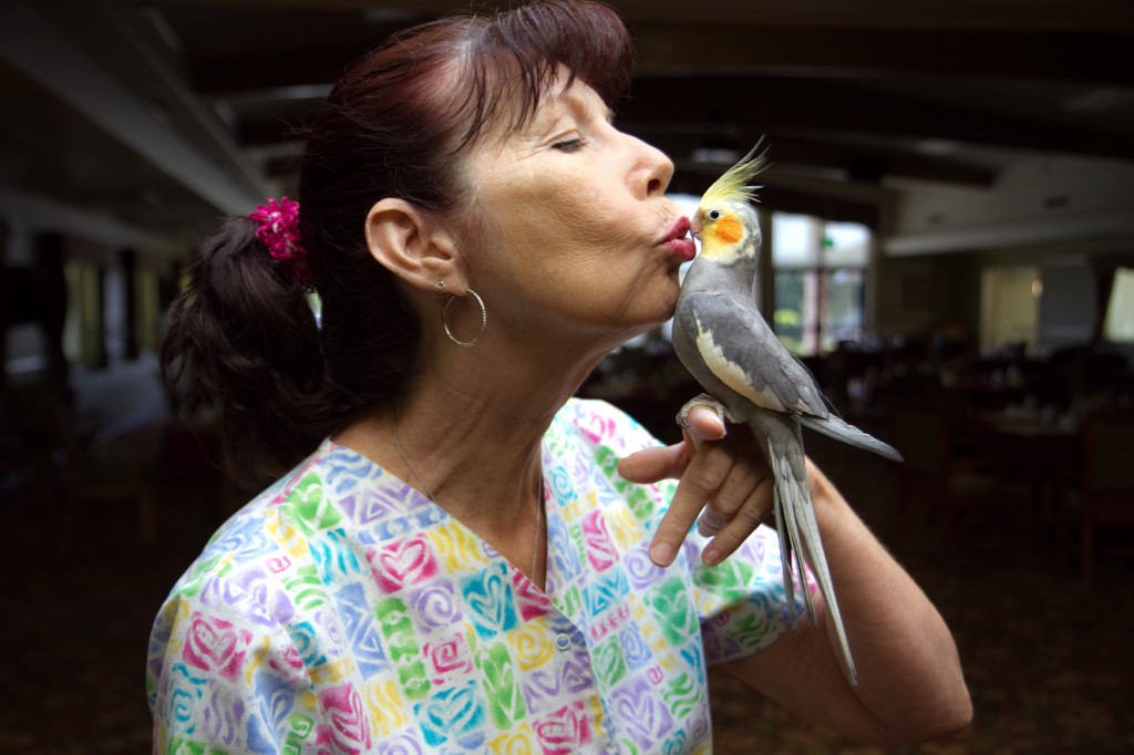 Picture of skilled nursing staff kissing a parrot.