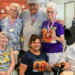 elderly residents pose wearing medals, around Dinora Negrete, the staff member who started the "walk to Kansas" challenge.